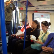 Early evening commuters travelling on Picadilly line tube between Hammersmith and Acton Town