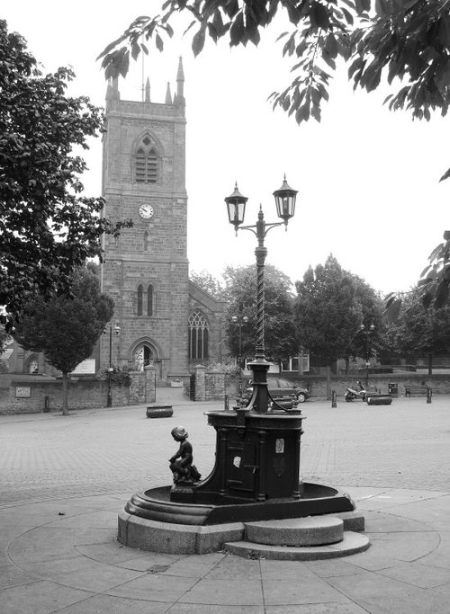 The fountain in the Market Place at Ilkeston in Derbyshire with St Mary's Parish Church.