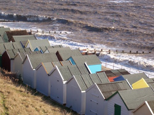 Felixstowe:  Beach huts and rough sea