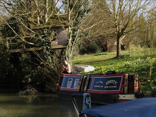 A tree-house (with owner, eating sandwich) by the Oxford canal, Lower Heyford, Oxfordshire.