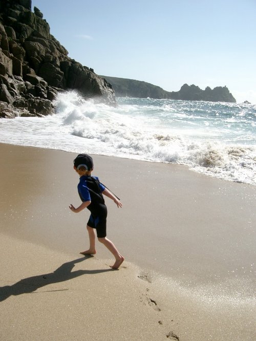 My son enjoying the waves at Porthcurno