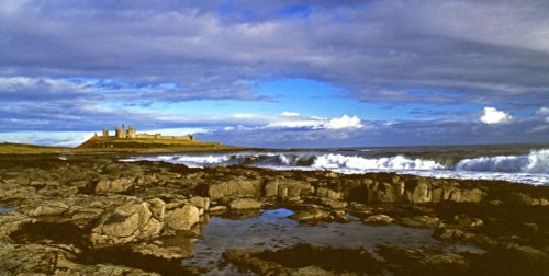 Dunstanburgh Castle, and shoreline seascape.
