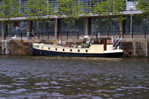 There are lots of narrow boats moored along the river banks.