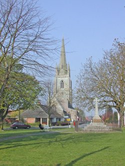 Helpringham in Lincolnshire showing the village green, war memorial and church.