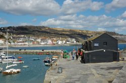 A view of the Marine Aquarium on the old Cobb with Lyme regis, Dorset, in the background.