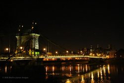 London Hammersmith Bridge at night from the towpath on the Barnes side of the River Thames. Wallpaper