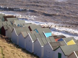 Felixstowe:  Beach huts and rough sea