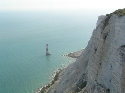 The lighthouse at Beachy Head, East Sussex, dwarfed by the while cliffs above it. Wallpaper