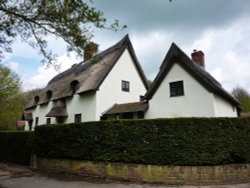 Thatched Houses on a busy road side Wallpaper