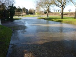Water pouring along the road at Mettingham Wallpaper