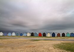 Stormy sky over beach huts Wallpaper