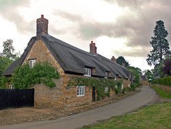 Thatched cottages under a gloomy sky