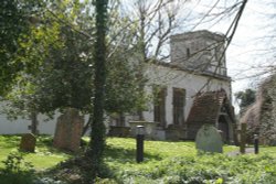 The Church of St. Michael and All Angels, Letcombe Bassett, set amongst the primroses in the churchyard Wallpaper