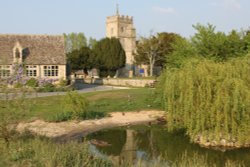The duck pond, Ducklington, with St. Bartholomew's Church behind