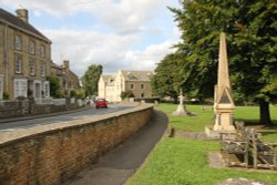 The memorial fountain and, in the background, the war memorial in Shipton-under-Wychwood Wallpaper