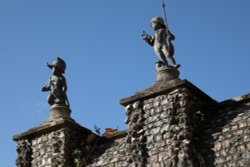 Statues of boy soldiers on flint wall near Greys Court House