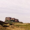View of Bamburgh Castle from approaching coastal road.