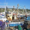 A trawler making ready to go to sea, from the Cobb harbour at Lyme Regis, Dorset.