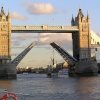 Tower Bridge opens to let through a masted ship