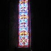 Coloured light shines through a stained glass window and on to the sill at Dover Castle