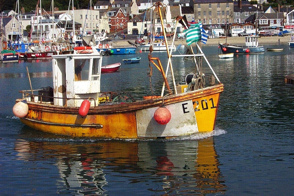 Fishing boat leaves harbour at Lyme Regis.
