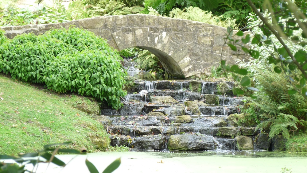 An arched bridge in the Japanese section with a waterfall