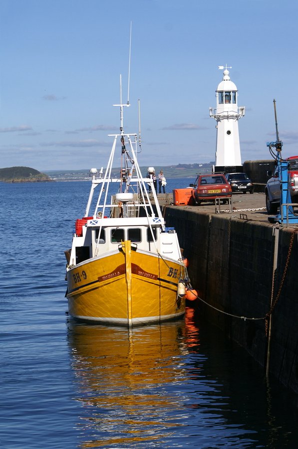 Fishing boat tied up at the harbour wall.