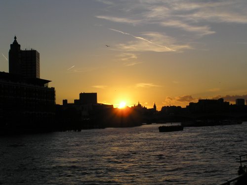 The London skyline at sunset, seen from a river boat