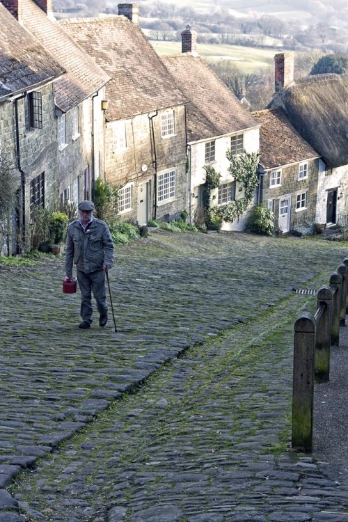 Old man walking through picturesque English village