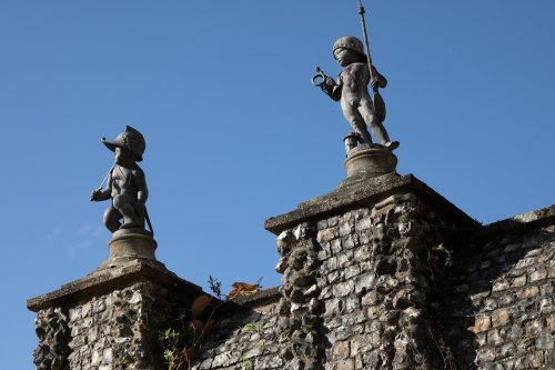 Statues of boy soldiers on flint wall near Greys Court House