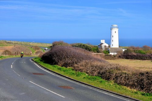 Motorbike Passing the Old Lower Light at Portland Bill in Dorset