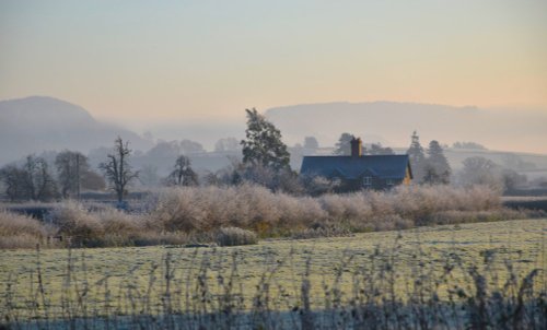 Cottage in a winter landscape at Brampton Bryan..