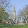 Helpringham in Lincolnshire showing the village green, war memorial and church.