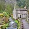 Peakshole Water Flowing Through Castleton with the Cliffs Above