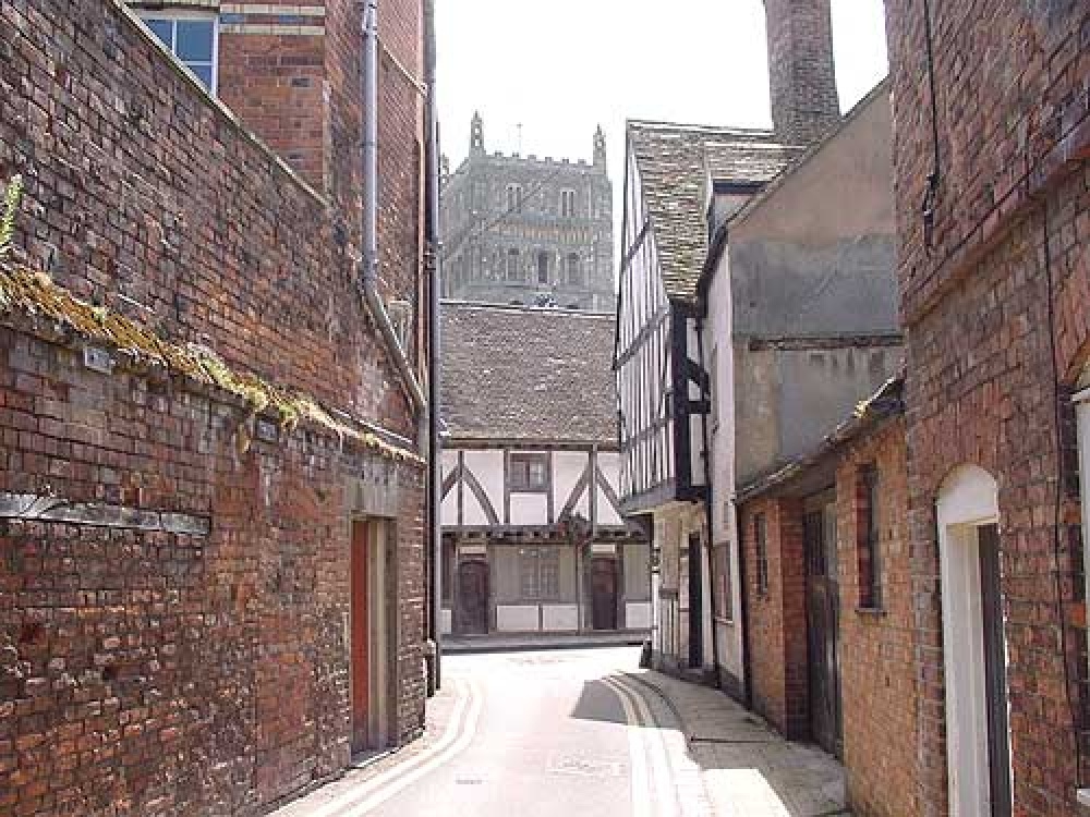 A view of Tewkesbury Abbey from with a street in the town of Tewkesbury.