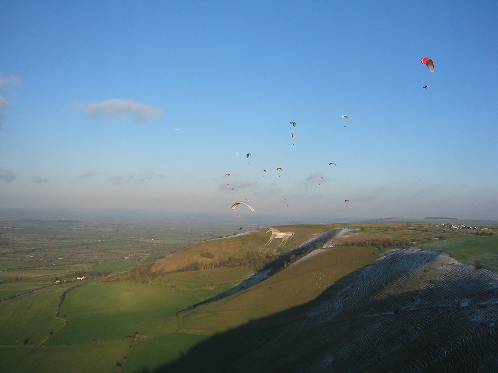 Paragliders flying over Westbury White Horse, Wiltshire