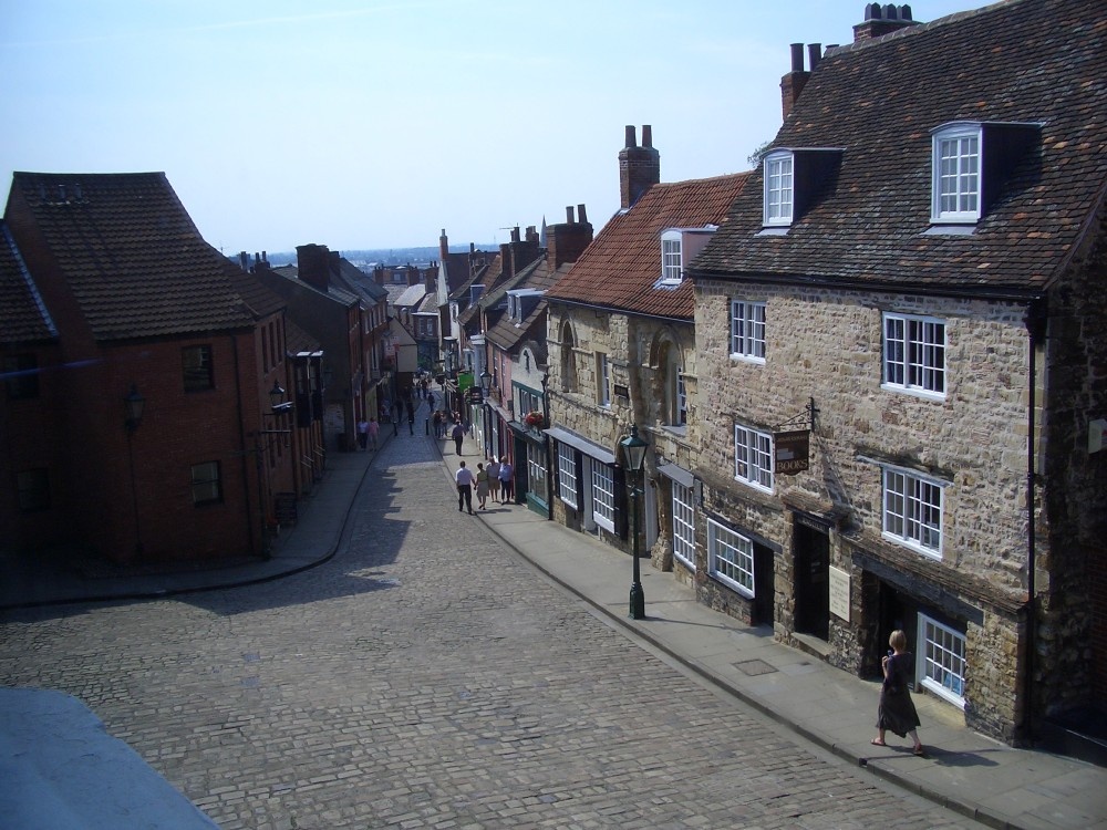 Window view along the bottom of ancient and cobbled Steep Hill, Lincoln.