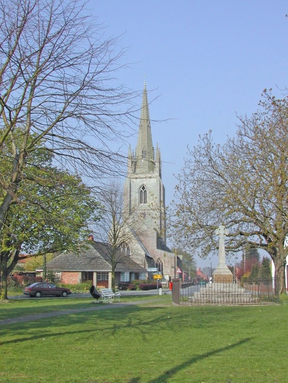 Helpringham in Lincolnshire showing the village green, war memorial and church.