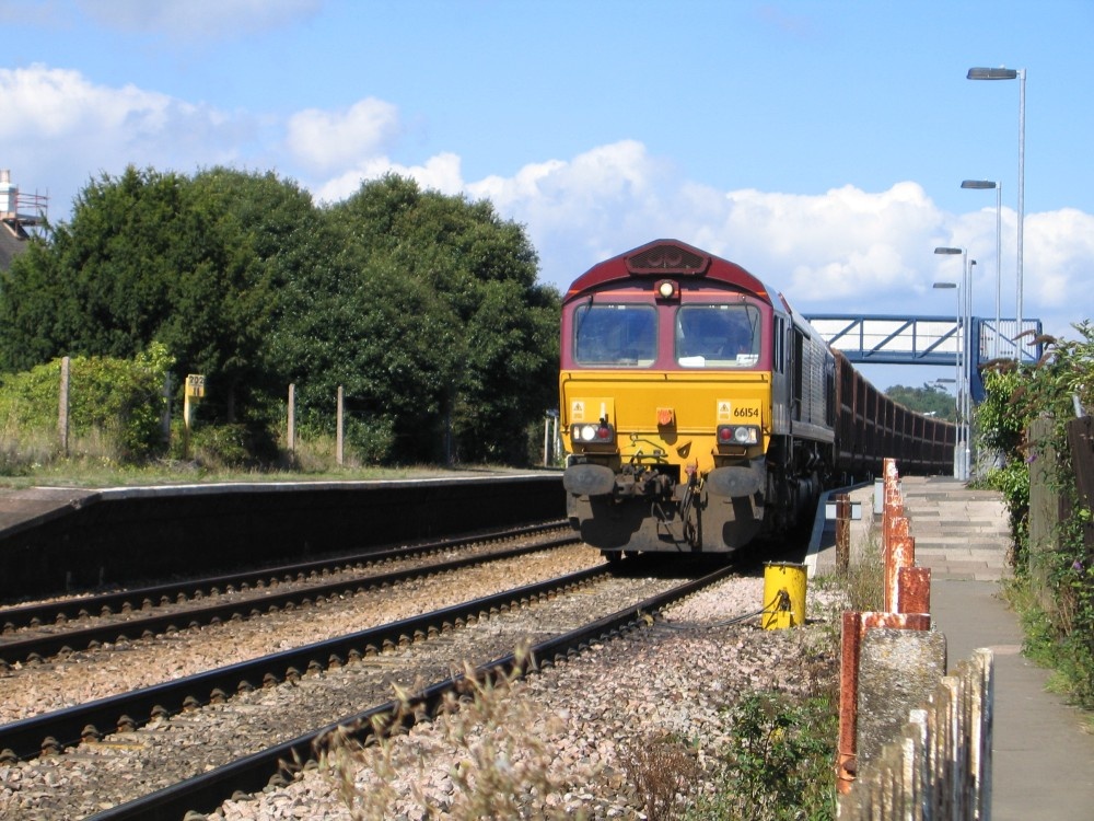 A class 66 freight train thunders through Starcross station, Devon