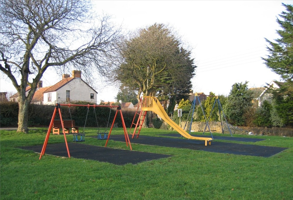 Childrens swings on the village green, Pawlett, Somerset.