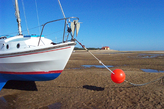 The harbour at Wells-next-the-Sea at low tide. RNLI lifeboat house in the distance.