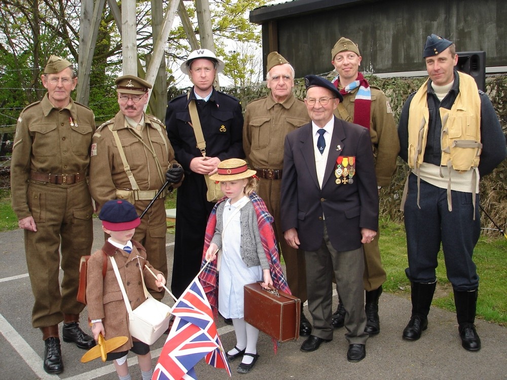 Mainwaring\'s Mob proudly pose with one of the veterans at Eden Camp, Malton, North Yorkshire.