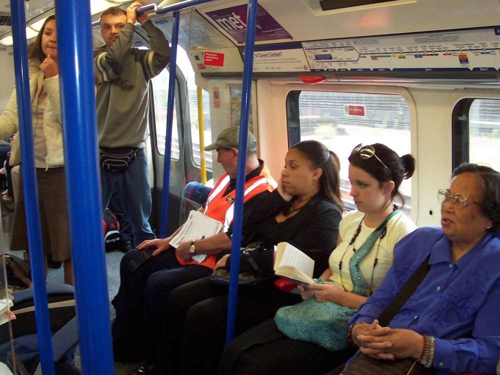 Early evening commuters travelling on Picadilly line tube between Hammersmith and Acton Town