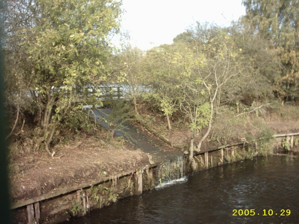 Fishing Pond overflowing into the river Tame at Reddish Vale, Stockport