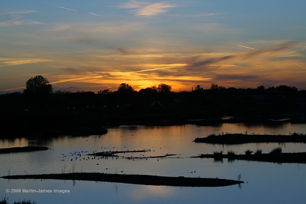 Photograph of The London Wetland Centre. Sunset over lagoon.