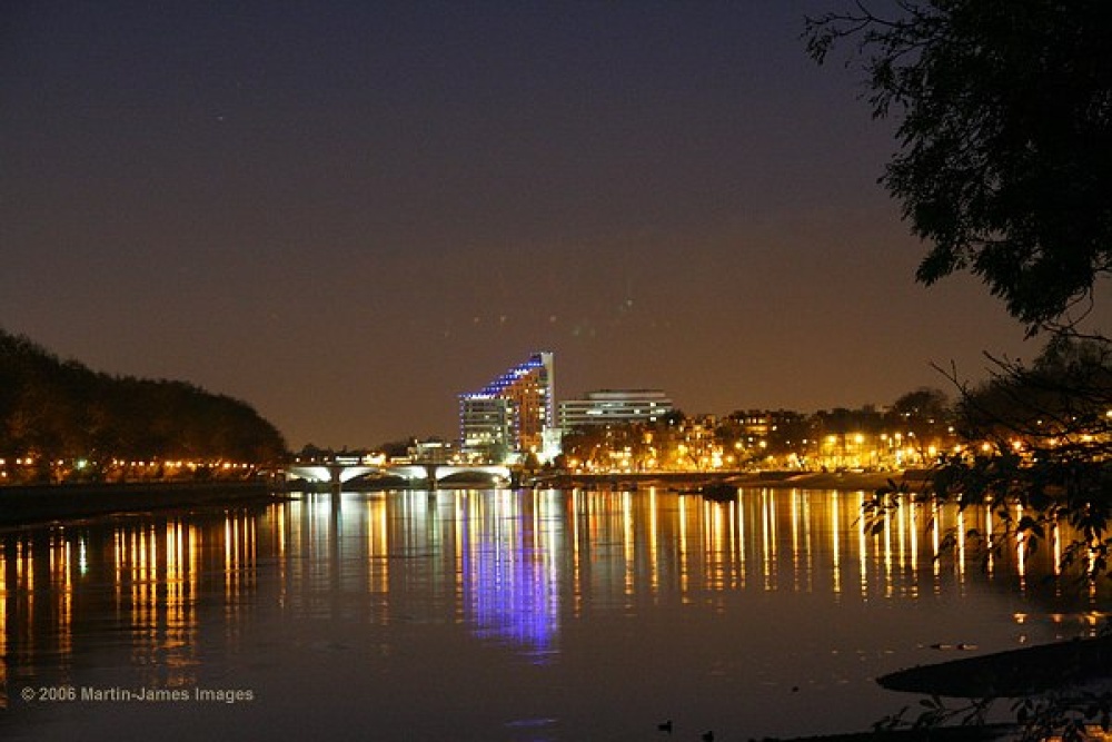 Photograph of London Putney at night seen from the towpath on the Barnes side of the River Thames.