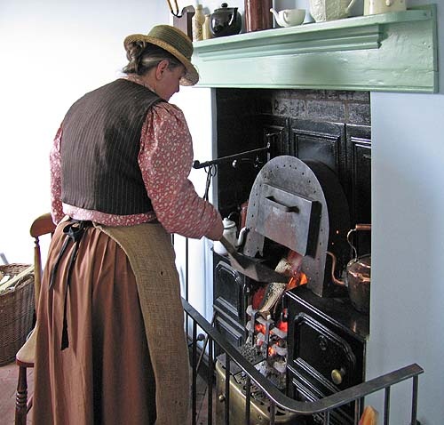 Stoking the kitchen stove at Blists Hill, Shropshire