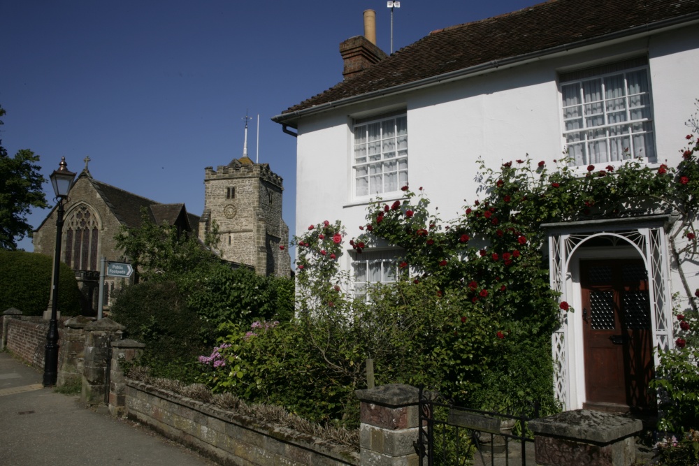 Cottage in village with  flowers and Church