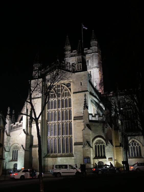 Bath Abbey at night, with a view of the large stained glass window