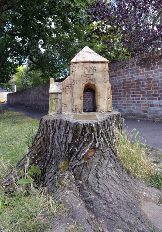 A carving on a felled tree of the Abbey Gate of Faversham.